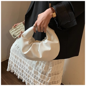 Close-up of the white pleated cloud bag showing the soft PU leather and knotted handle detail