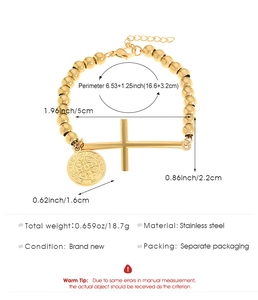 Vue détaillée d'un bracelet en perles d'acier doré avec croix et médaille Saint-Benoît