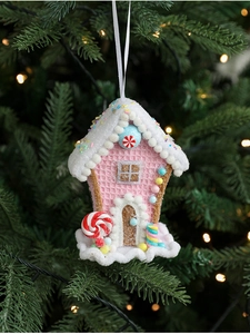 Close-up of pink ice cream cone ornament with snow top hanging on a Christmas tree