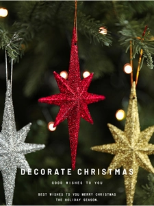 Detail of red, gold and silver glittered 8-point star ornaments on a Christmas tree
