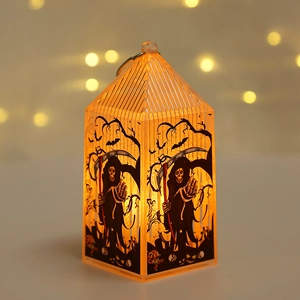 Detail of Halloween pumpkin lantern with grim reaper and bat silhouettes in warm lighting