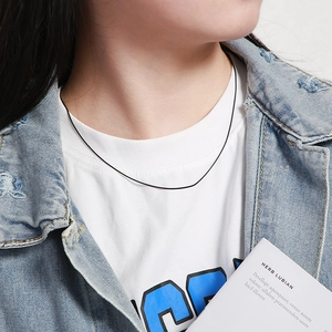 Close-up of a minimalist black thin cord necklace on neck showing fine texture and fit
