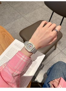 Close-up of stylish square dial watch with grey silicone strap and silver case
