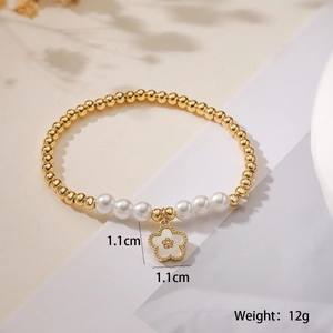 Detail showing 1.1cm white flower pendant and pearls on 18K gold plated beaded bracelet