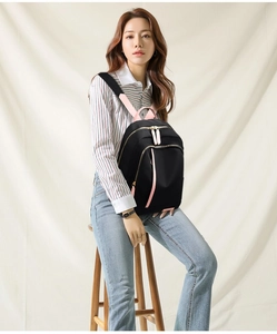 Close-up of lightweight nylon backpack with pink shoulder straps and gold zipper details
