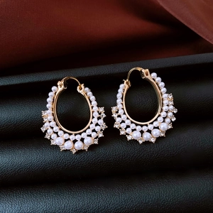 Close-up of French vintage gold hoop earrings with white pearls and sparkling diamonds