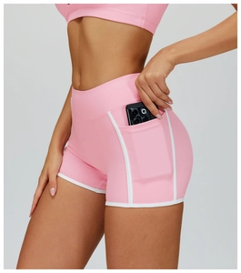 Detail of pink high-waisted gym shorts featuring a side pocket for a smartphone and white trim