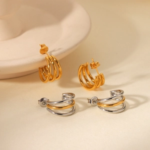 Detail of 18k gold and silver two-tone triple layer C-shaped hoop earrings
