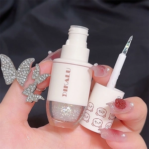 Dettaglio dell'ombretto liquido glitterato con tappo a orsetto e applicatore a pennello