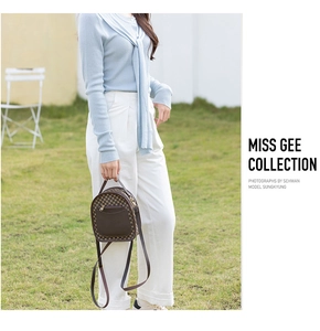 Outdoor shot of a vintage brown checkered mini backpack with a front zipper pocket
