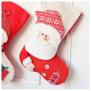 Detail of red knit Christmas stocking with 3D Santa plush doll and checkered tree patch