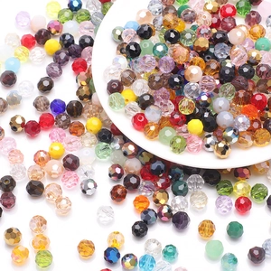 Close-up of faceted crystal glass football beads in various colors for jewelry making