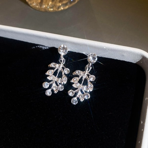 Macro shot of sparkling leaf-shaped crystal drop earrings in a black velvet jewelry box