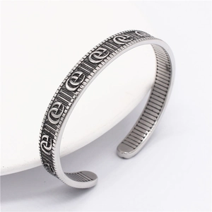 Détail macro du bracelet jonc en acier titane rétro avec motifs de chaîne gravés