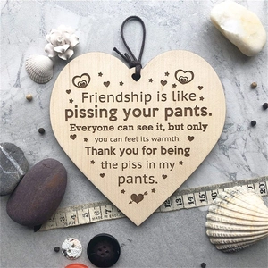 Wooden heart-shaped friendship plaque with humorous quote on a marble background