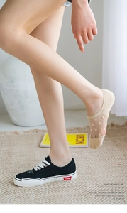 Detail of beige breathable mesh no-show socks worn with black canvas sneakers