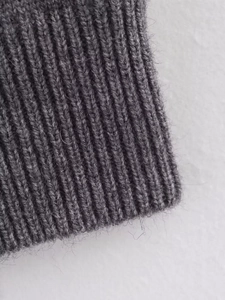 Close-up of gray ribbed knit texture showing soft wool-like fibers and detailed stitching