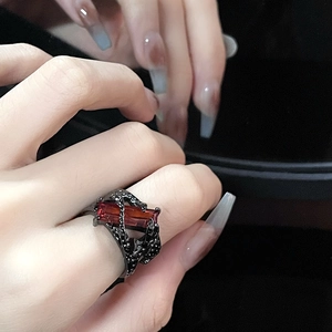 Gothic thorn open ring with red rectangular zircon in dark plating worn on finger
