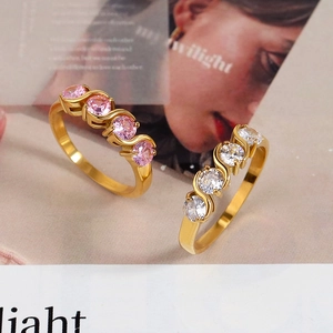 Minimalist gold rings with pink and clear zircons in a wavy geometric design