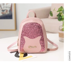 Detailed macro of pink sequin mini backpack with cat ears and gold logo lettering