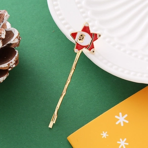 Détail d'une barrette de Noël dorée avec un motif de Père Noël en émail en forme d'étoile