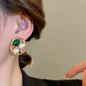 Close-up of vintage cluster stud earring with emerald crystal and white pearls