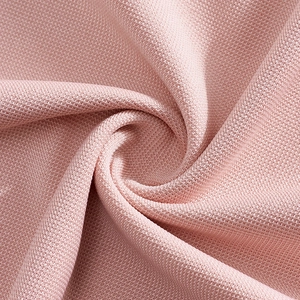 Close-up of pink moisture-wicking polo shirt fabric showing soft texture and fine knit weave