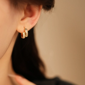 Vue détaillée de boucles d'oreilles créoles plaquées or 18K avec zircons et blanc crème