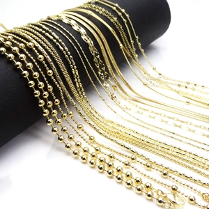 Collection of gold bead and snake chains displayed on a professional black jewelry stand