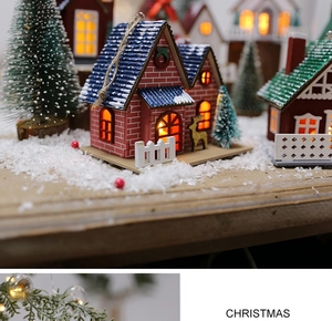 Close-up of lighted Christmas wooden house with snow texture and reindeer detail