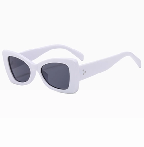 Close-up of white acetate frames with metal rivet details and dark grey lenses