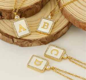 Detailed view of square 18K gold plated steel letter pendants with sparkling crystals