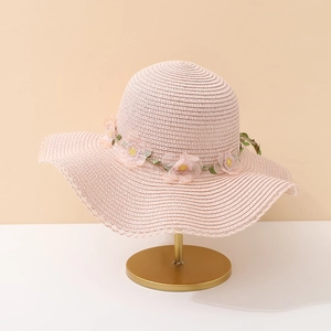 Détail d'un chapeau de soleil en paille rose pour filles avec fleurs en résille