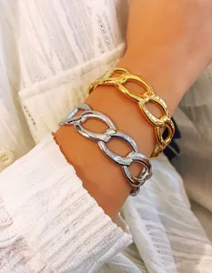 Close-up of chunky gold and silver chain link bracelets on a model for a chic look