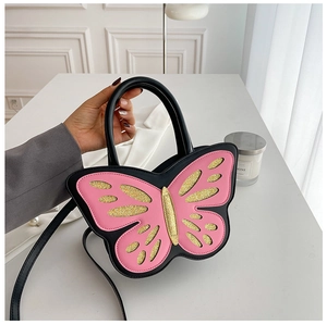 Detail of butterfly-shaped pink and black crossbody bag with sequin wings and top handle
