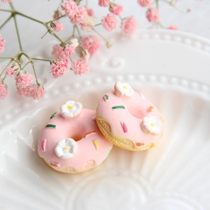 Makroaufnahme von Miniatur-Resin-Donuts in Rosa mit weißen Blumen für DIY-Handyhüllen