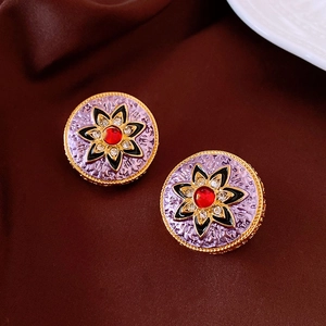 Macro detail of vintage floral earrings with red gemstones and enamel on silk