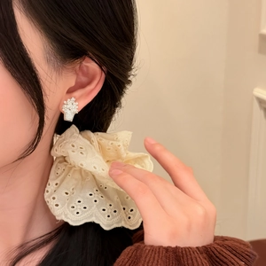 Close-up of elegant flower basket zircon and pearl stud earrings worn by Asian model