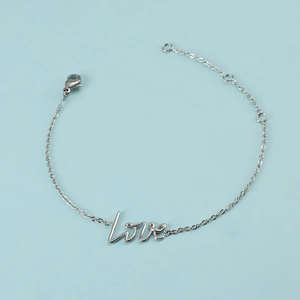 Détail d'un bracelet en acier inoxydable argenté avec un pendentif en cursive love