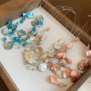 Detailed macro view of multi-layered seashell and crystal beaded pendant necklace