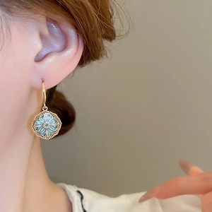 Vintage gold plated mandala earrings with green zircon and blue enamel on model