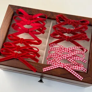 Ensemble de barrettes à nœuds en velours et satin rouge sur un coffret à bijoux rétro
