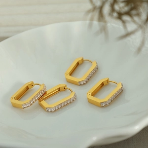 Rectangular 18K gold plated hoop earrings with zircon stones on a white ceramic tray
