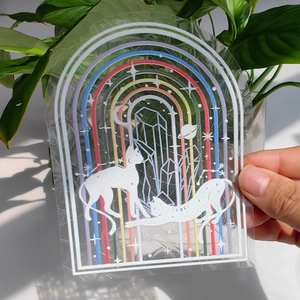 Macro detail of holographic arch suncatcher sticker with cat and celestial moon pattern