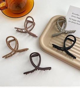Matte finish hair clips in neutral colors on a stylish tray for bun hairstyles
