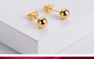 Macro view of polished gold plated ball stud earrings with standard butterfly backings