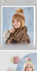 Close-up of children's winter knit hat featuring fluffy faux fur pompom and fleece lining