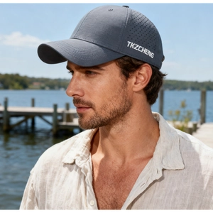 Dettaglio di cappello grigio scuro con fori di ventilazione laser e logo laterale