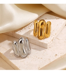 Detailed shot of gold and silver lava style rings on travertine surface with silk