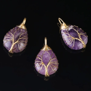 Detailed view of three purple natural stone teardrop pendants with gold wire tree of life